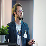 Ein Referierender spricht auf der Bühne