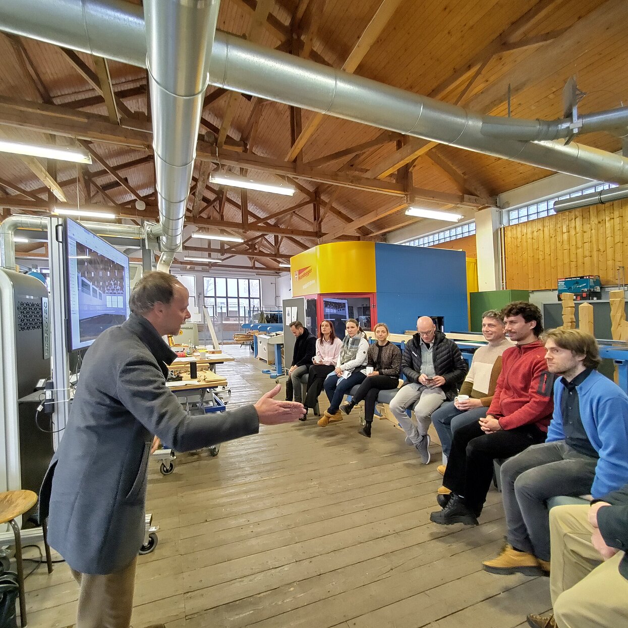 Referent vor einer Gruppe in einem Labor-Sägewerk. 