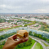 Someone holding a cup of the dessert in front of the skyline fiew of Munich