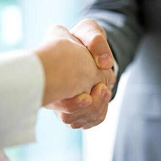 Zwei Personen geben sich die Hand