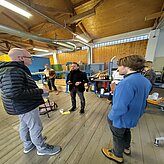 Gruppe von Menschen versammelt in einem Labor-Sägewerk. 