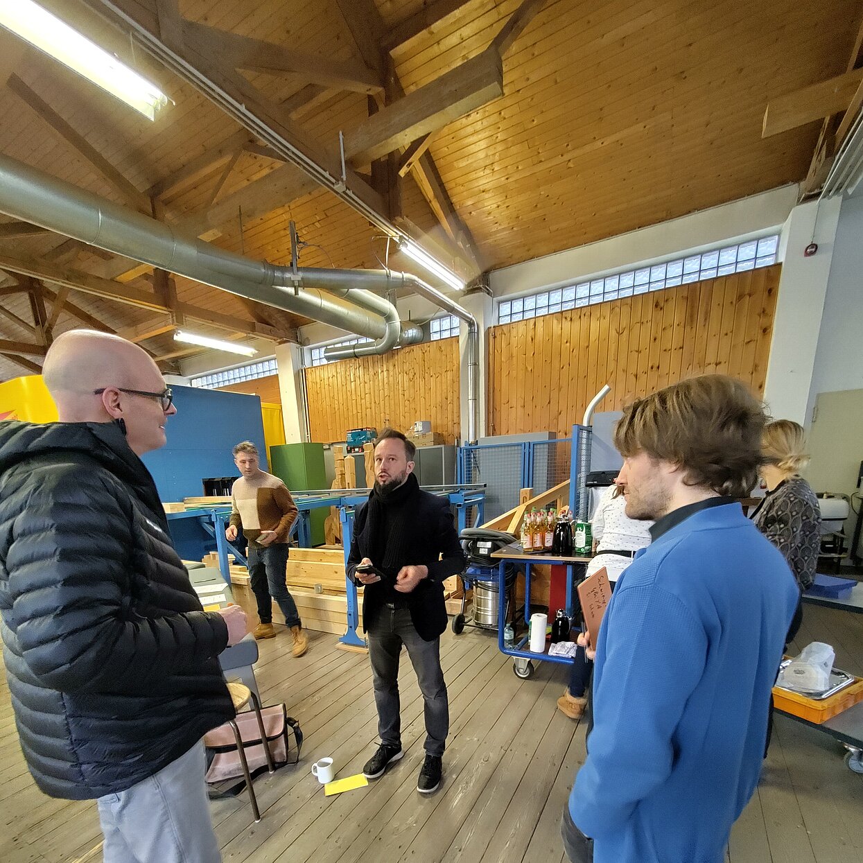 Gruppe von Menschen versammelt in einem Labor-Sägewerk. 