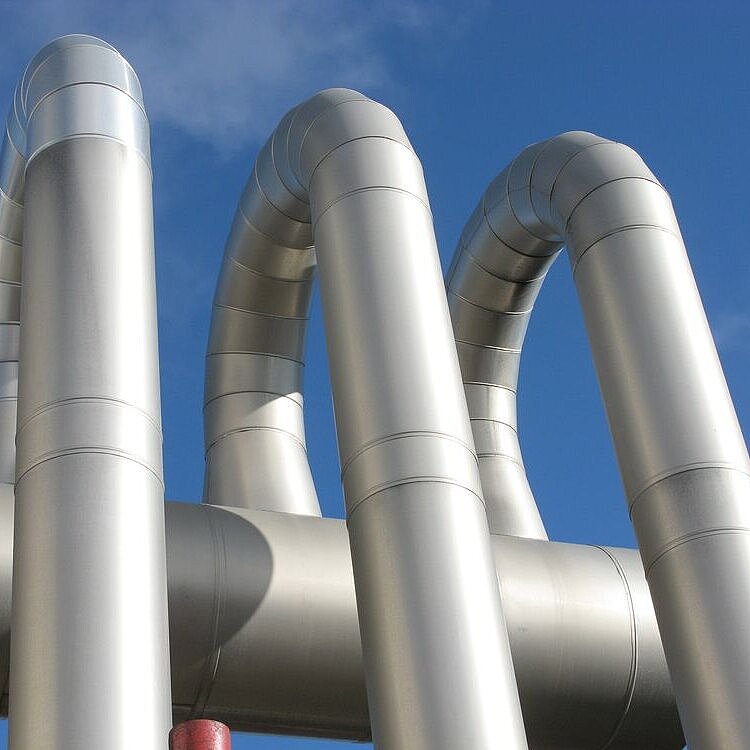 Drei nebeneinanderstehende Fernwärmerohre