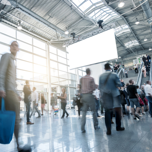 Menschen laufen geschäftig durch die Messehalle