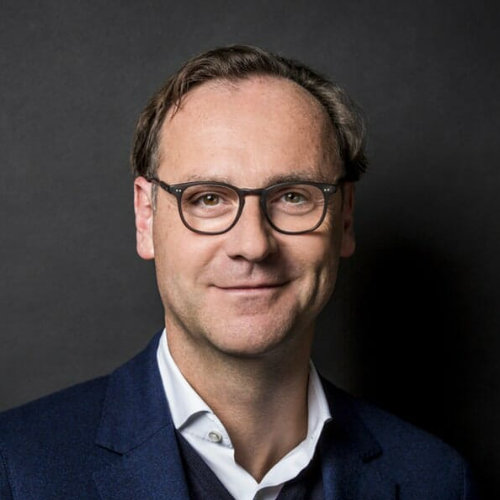 Mann mit Brille und schwarzem Anzug